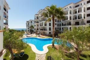 an aerial view of a resort with a swimming pool and palm trees at Beach Apartment Marina Duquesa in Manilva
