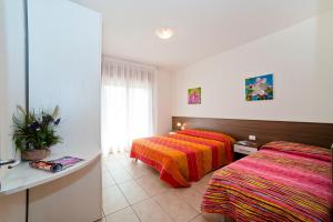 a bedroom with two beds and a window at Residence Galleria Gran Madò in Caorle