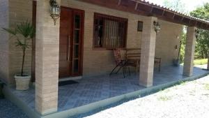 une maison avec une terrasse couverte et un patio dans l'établissement Pousada Punta Cana, à Estância Teixeira