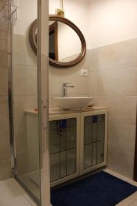 een badkamer met een wastafel en een spiegel bij Casa "ALCENTRO" in Assisi