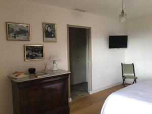 a bedroom with a bed and a desk and a tv at Casa Santa Lucia in Bocognano