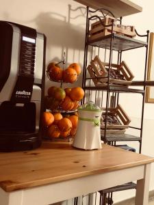 um balcão com uma banca de frutas com laranjas e um liquidificador em Residenza Murat BB em Caserta