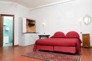 a bedroom with a red bed in a white room at B&B Alle Querce in San Giovanni Rotondo