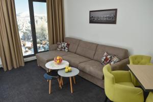 a living room with a couch and a table and chairs at Alibi Zlatibor in Zlatibor