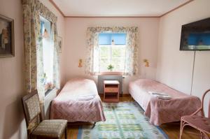 een slaapkamer met 2 bedden en een raam bij Odalgården Hotell, Kurs & Konferens in Marielund