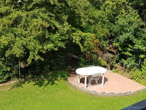 フリッツラーにあるFritzlar Ederauenの木の植わる庭の白いテーブルと椅子