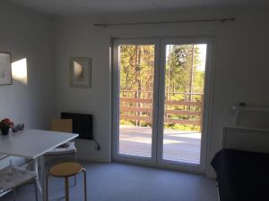 Habitación con puerta corredera de cristal, mesa y sillas. en Fjällstuga en Idre