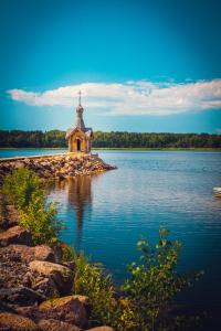 a church on a island in the middle of a lake at Okunevaya Holiday Park in Ozerki