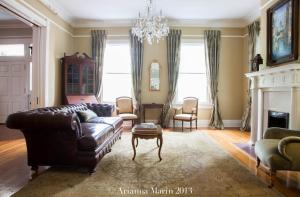 a living room with a leather couch and a chandelier at The Twelve Oaks Bed & Breakfast in Covington