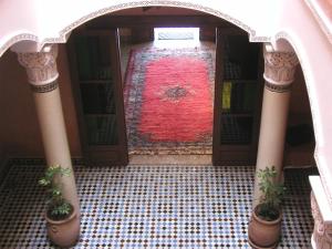 an open door with a red rug on a tiled floor at Residence Essaouira Mogador in Essaouira