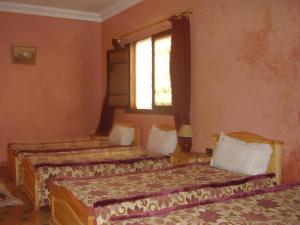 a bedroom with two beds and a window at Residence Essaouira Mogador in Essaouira
