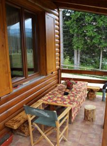 a table and a chair on the porch of a cabin at Mountain Family House Zara in Žabljak