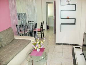 a living room with a couch and a table with flowers at Apartments Petrovic in Krimovice