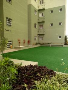 a green lawn in front of a large building at Condominio Garden Indaia in Caraguatatuba