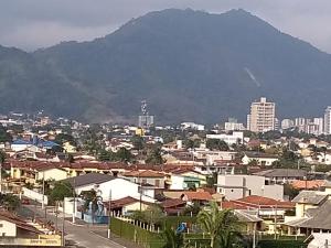 a city with buildings and a mountain in the background at Condominio Garden Indaia in Caraguatatuba