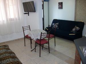 a living room with a table and chairs and a couch at Apartments Petrovic in Krimovice
