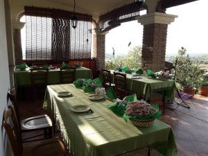 een eetkamer met groene tafels, stoelen en ramen bij Agriturismo Arena Del Sol in Fertilia