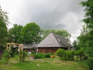 a large wooden house in a yard with trees at Siedlisko Sobibór in Sobibór