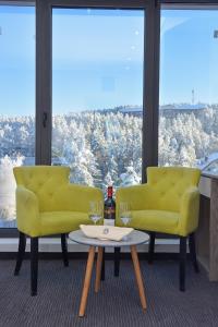 un soggiorno con due sedie gialle e un tavolo di Alibi Zlatibor Inn a Zlatibor