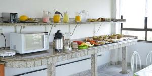 una mesa con platos de comida y un microondas en Hoteis Cattoni, en Lages