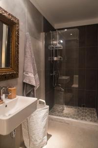 een badkamer met een wastafel en een douche bij Athenian Neoclassical Apartment in Athene