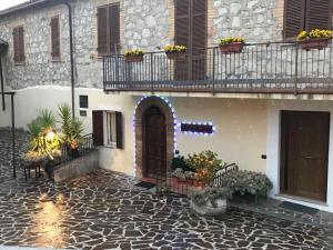 een gebouw met een deur en een balkon met bloemen bij B&B Le Torrette in Campello sul Clitunno
