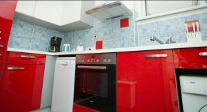 - une cuisine rouge avec des placards rouges et un four noir dans l'établissement Cosy flat near Schönbrunn, à Vienne