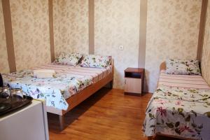 1 dormitorio con 2 camas y mesita de noche en Karavan-Saray Mizhvodne en Mizhvodne