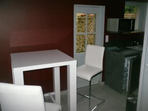 kuchnia z 2 białymi krzesłami i stołem w obiekcie La maison bleue w mieście Nogent-sur-Seine