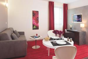 uma sala de estar com um sofá e uma mesa em Appart'City Confort Grenoble Inovallée em Montbonnot-Saint-Martin
