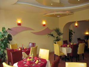 a restaurant with tables and chairs and an umbrella painted on the wall at Hotel am Hauptbahnhof in Schwerin