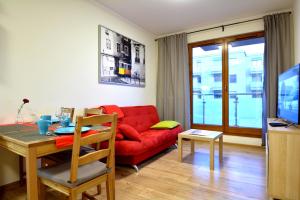 a living room with a red couch and a table at Apartament Bema 37 in Wrocław