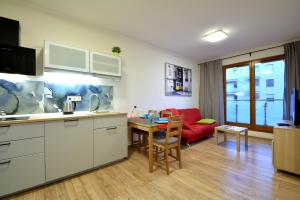 a kitchen and living room with a red couch at Apartament Bema 37 in Wrocław