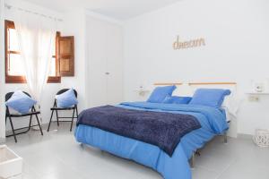 トッサ・デ・マールにあるApto reformado a 100m de playaの白いベッドルーム(青いベッド1台、椅子2脚付)