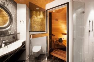 a bathroom with a toilet and a sink at Hotel Aateli Hillside in Vuokatti +6 photos