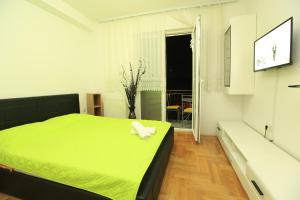a bedroom with a green bed with a towel on it at Nova Apartments in Ohrid