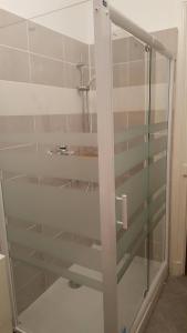 a glass shower door with a sink in a bathroom at la villa mersoise in Mers-les-Bains