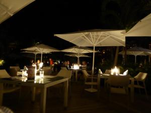 a restaurant with tables and white umbrellas at night at Suites at Mayan Palace Vidanta Resort Riviera Maya in Playa del Carmen