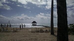 people standing on a beach with chairs and a pier at Suites at Mayan Palace Vidanta Resort Riviera Maya in Playa del Carmen