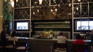 a group of people sitting at a bar in a restaurant at Suites at Mayan Palace Vidanta Resort Riviera Maya in Playa del Carmen