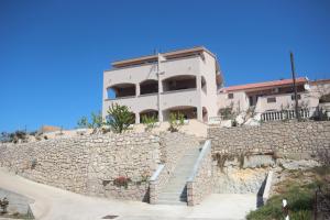 un edificio en la parte superior de una pared de piedra en Apartments Njaco, en Ražanac