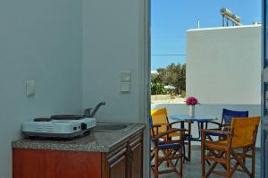 a kitchen with a sink and a table with chairs at Atlantida Hotel in Koufonisia