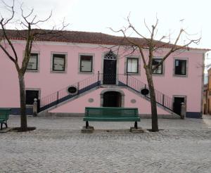 a pink building with a bench in front of it at Casa do Brigadeiro in Lajeosa