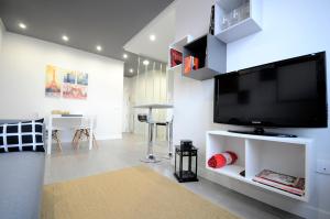 el11 apartamento في سمورة: غرفة معيشة مع تلفزيون بشاشة مسطحة كبيرة على جدار