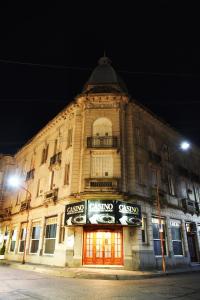 un grand bâtiment dans une rue la nuit dans l'établissement Gran Texier Hotel Casino, à Concepción del Uruguay
