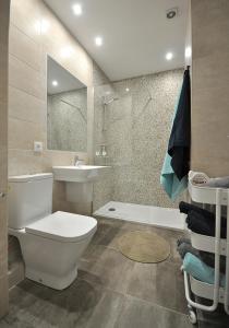 a bathroom with a toilet and a sink and a tub at el11 apartamento in Zamora