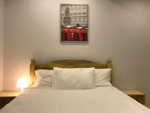 a bedroom with a bed with a picture on the wall at Umali Kayo at Megatower Residences II in Baguio