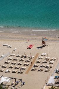 Una playa con un montón de sillas y un caballo. en Hotel Claudio, en Bergeggi