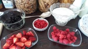 una mesa cubierta con cuencos de fresas y otros ingredientes en The Saddlery, en Greytown