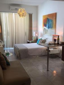 1 dormitorio con 1 cama y 1 mesa con lámpara en Copacabana: lounge lindo, confortável e com vista do mar, en Río de Janeiro